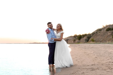 Photo of Wedding couple. Bride and groom standing on beach