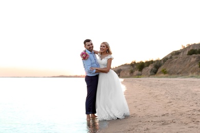 Wedding couple. Bride and groom standing on beach