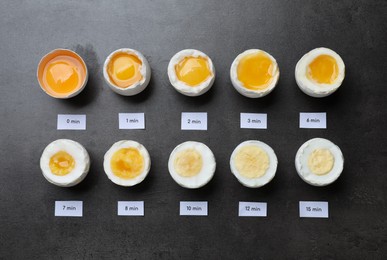 Photo of Different cooking time and readiness stages of boiled chicken eggs on dark grey table, flat lay