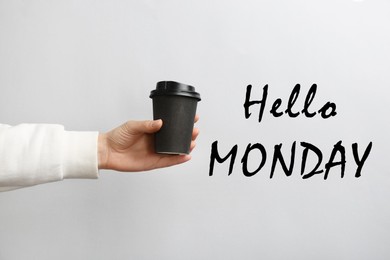 Hello Monday, start your week with good mood. Woman holding paper coffee cup on light background, closeup