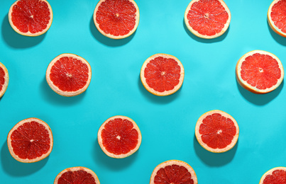 Tasty ripe grapefruit slices on blue background, flat lay