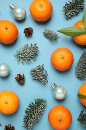 Photo of Composition with Christmas balls and tangerines on light blue background, flat lay