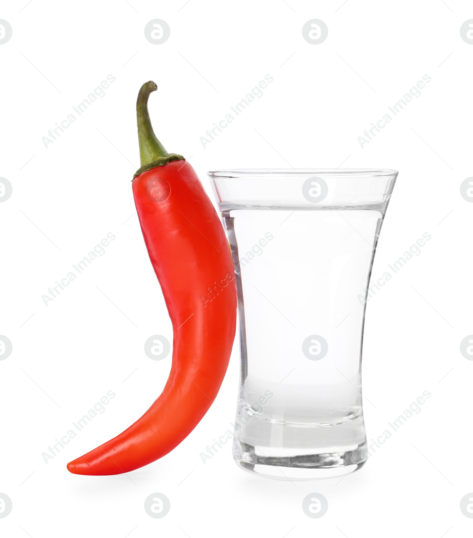 Photo of Red hot chili pepper and vodka in shot glass on white background