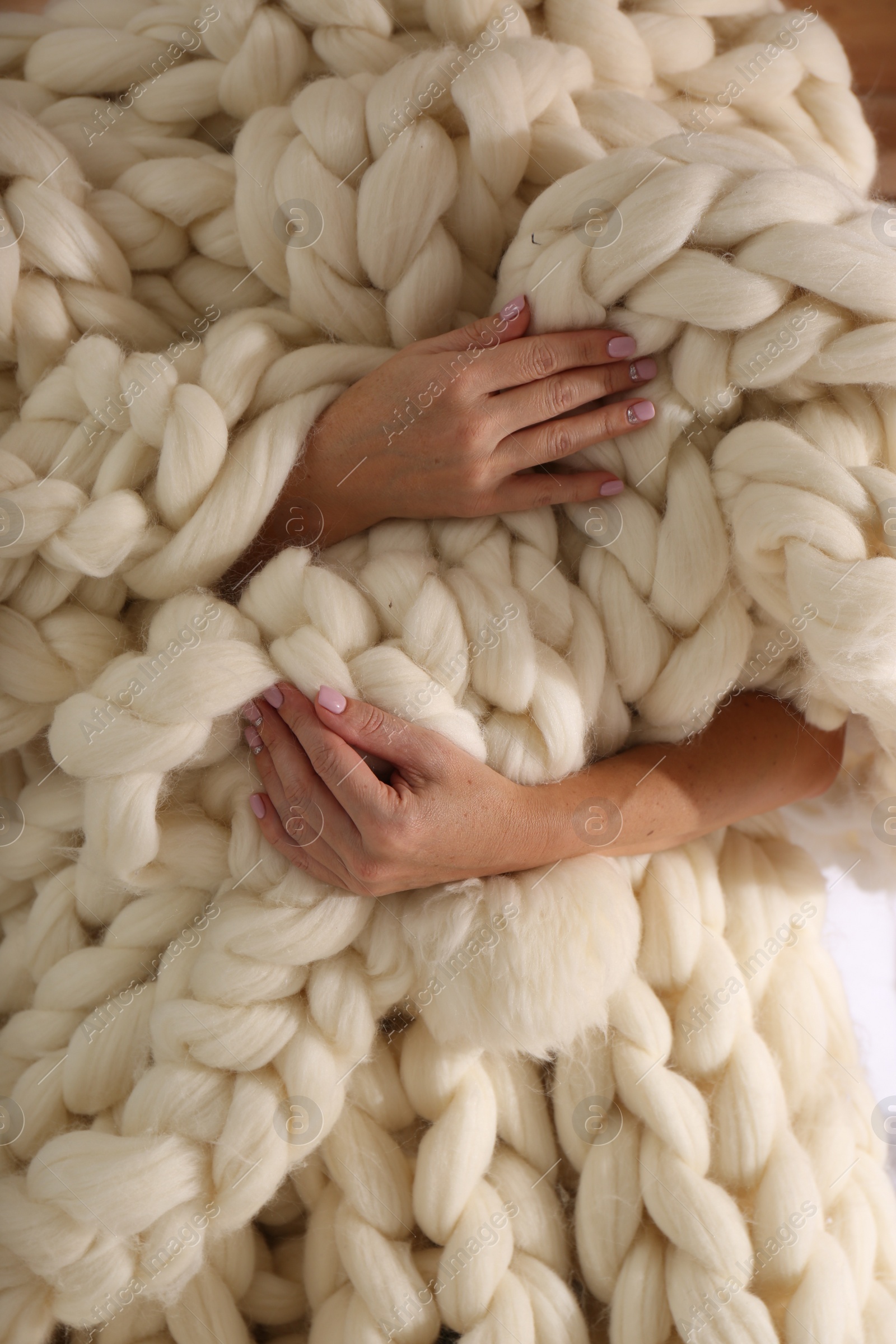 Photo of Woman wrapped with white knitted plaid, closeup