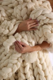 Woman wrapped with white knitted plaid, closeup