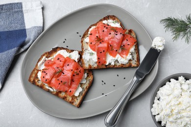 Photo of Delicious sandwiches with cream cheese, salmon and black sesame seeds served on light grey table, flat lay