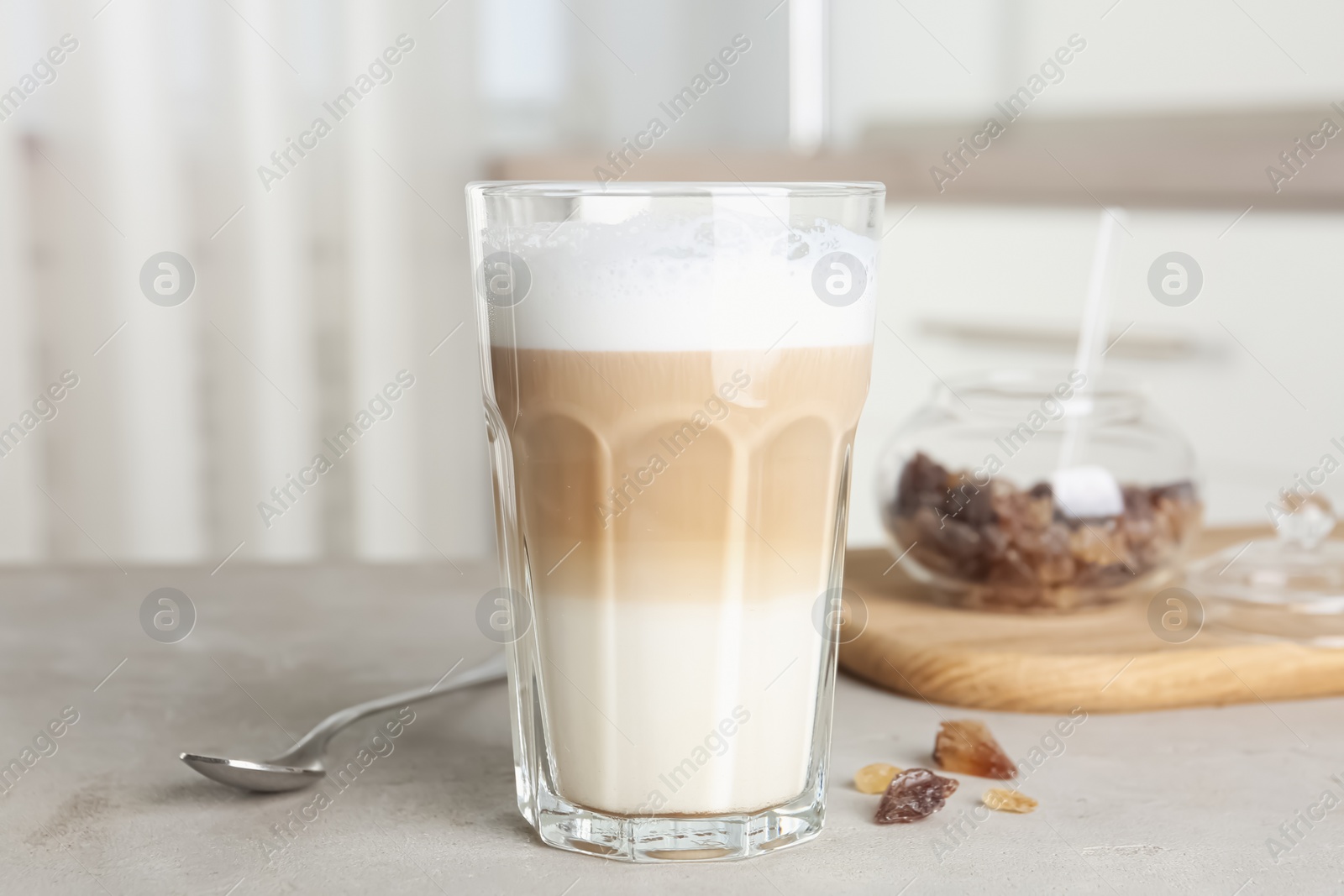 Photo of Delicious latte macchiato in glass on grey table indoors