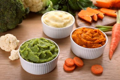 Photo of Bowls with tasty puree and ingredients on wooden table