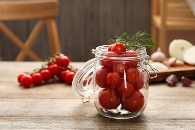 Photo of Pickling jar with fresh tomatoes on wooden kitchen table