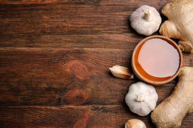 Photo of Fresh garlic and other natural cold remedies on wooden table. Space for text