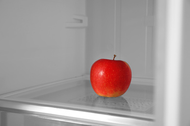 Red apple on shelf inside modern refrigerator