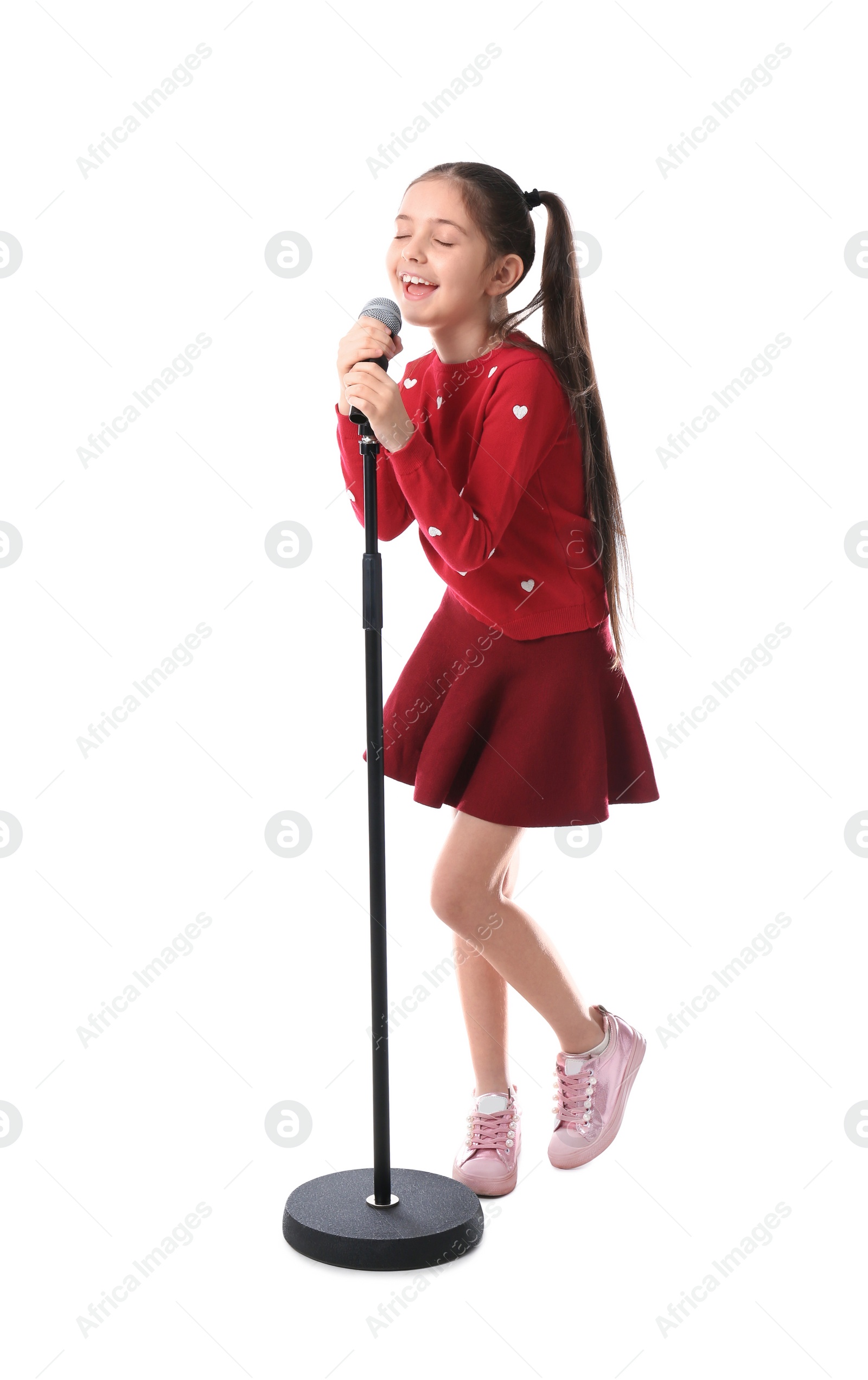 Photo of Little girl singing into microphone on white background