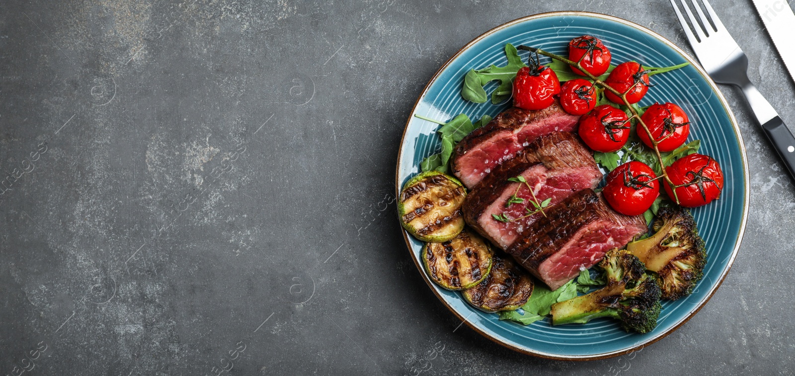 Image of Delicious sliced beef steak served on grey table, flat lay with space for text. Banner design