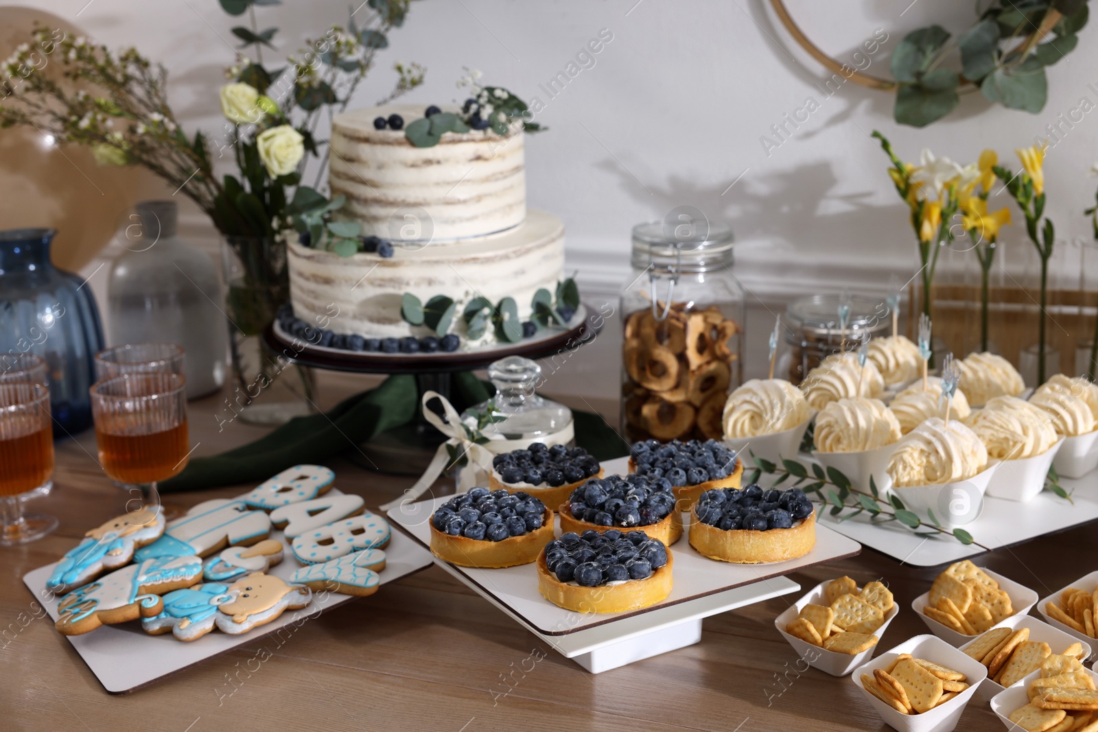 Photo of Beautiful cake and other treats on table in room. Baby shower party