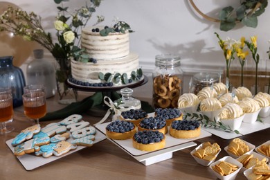 Beautiful cake and other treats on table in room. Baby shower party