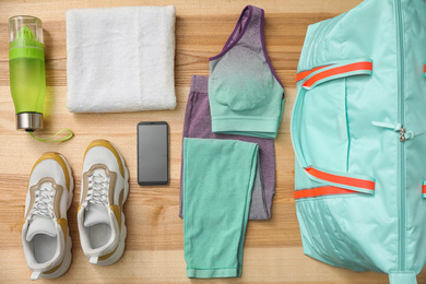 Flat lay composition with sports bag on wooden background