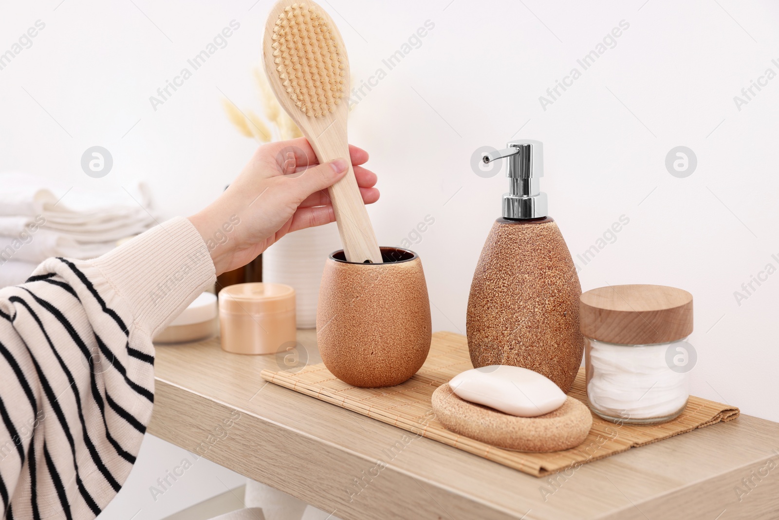 Photo of Bath accessories. Woman with brush indoors, closeup