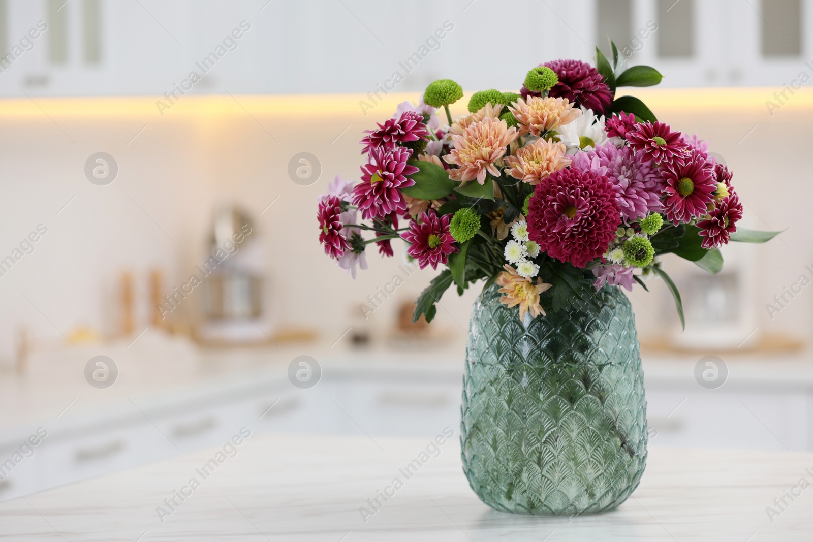 Photo of Bouquet of beautiful chrysanthemum flowers on table in kitchen, space for text