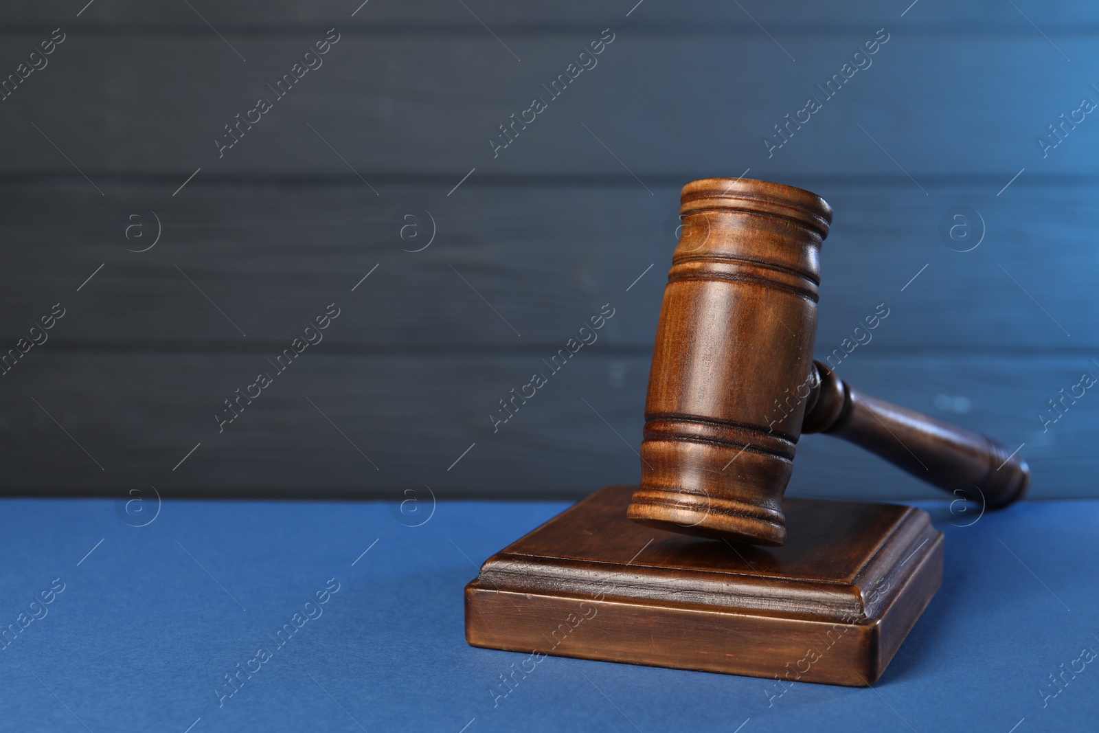 Photo of Wooden gavel on blue table, closeup. Space for text