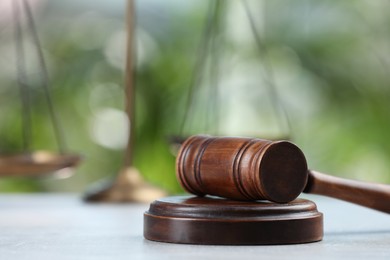 Photo of Wooden gavel on grey table against blurred background