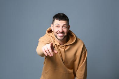 Handsome man laughing on grey background. Funny joke