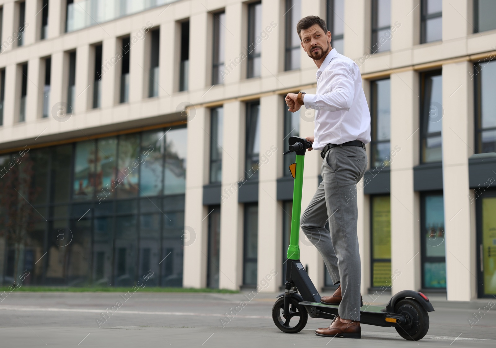 Photo of Businessman with modern kick scooter on city street, space for text