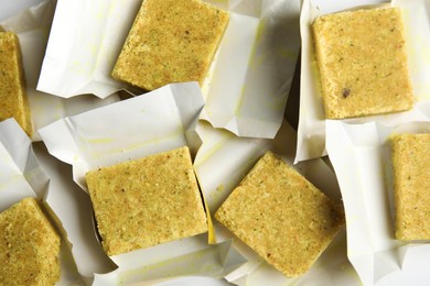 Photo of Bouillon cubes with wraps as background, top view