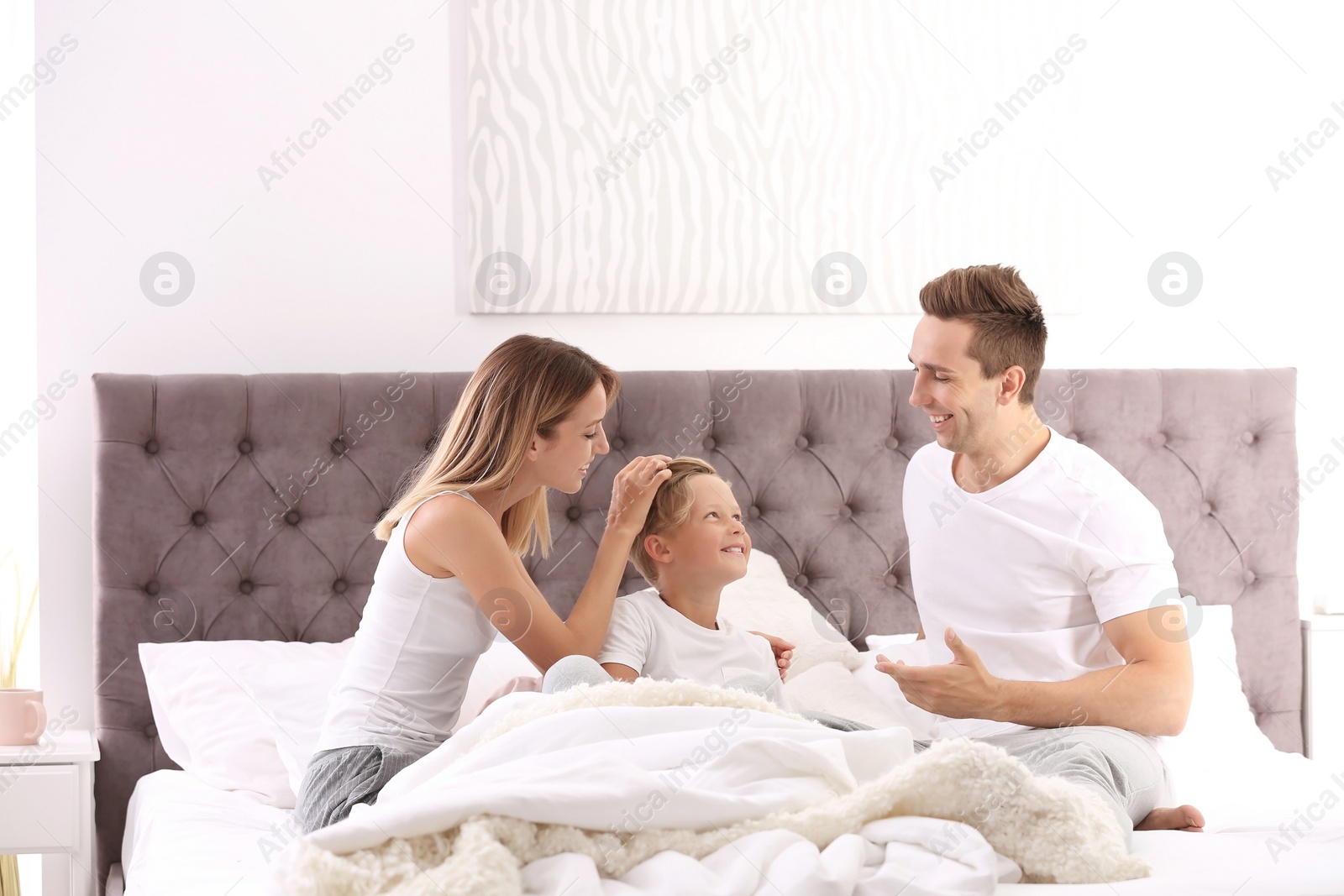 Photo of Happy family on bed with pillows at home