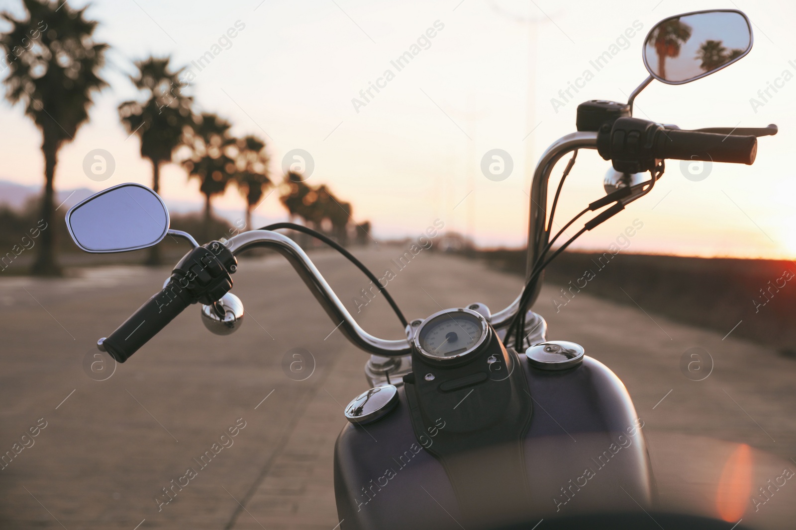 Photo of Modern black motorcycle on road at sunset