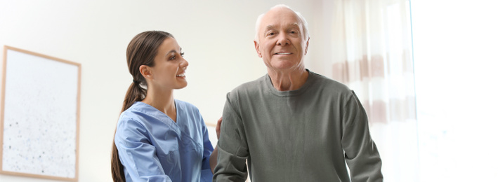 Image of Care worker helping elderly man in geriatric hospice. Banner design