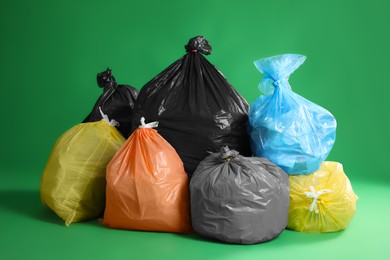 Photo of Trash bags full of garbage on green background