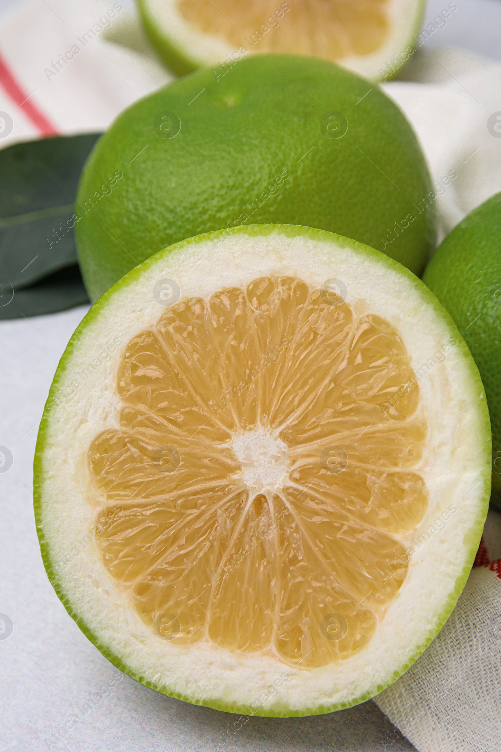 Photo of Whole and cut sweetie fruits on light table, closeup