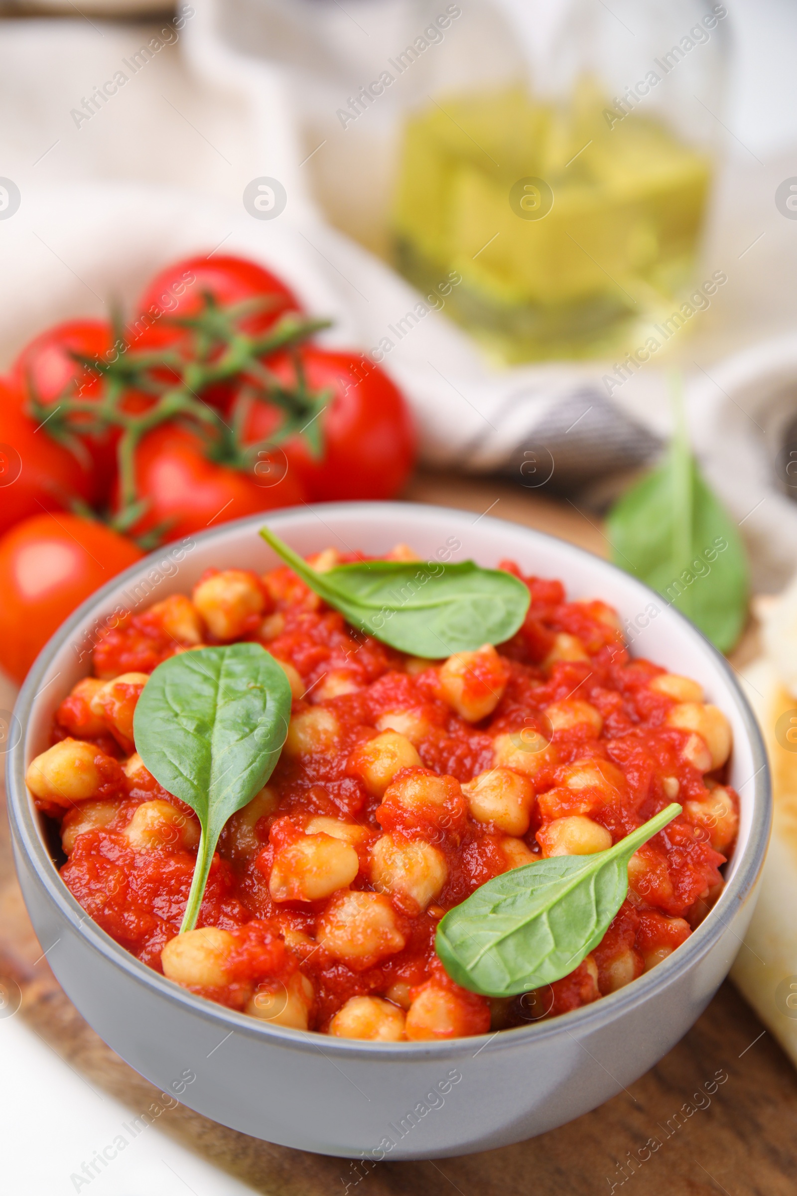 Photo of Delicious chickpea curry with basil in bowl, closeup