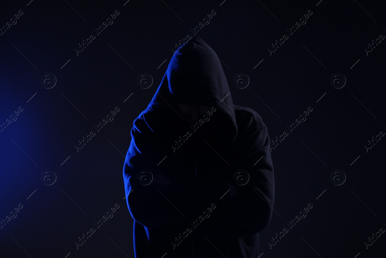 Photo of Man in hood on dark background. Cyber crime