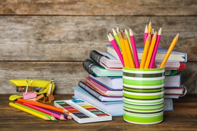 Different school stationery on table against wooden background