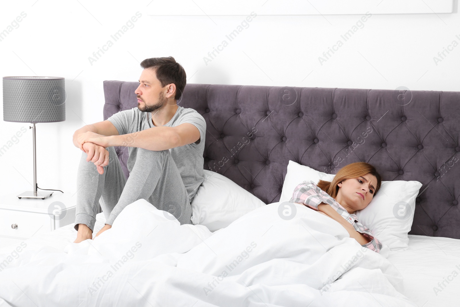 Photo of Couple with relationship problems ignoring each other in bedroom