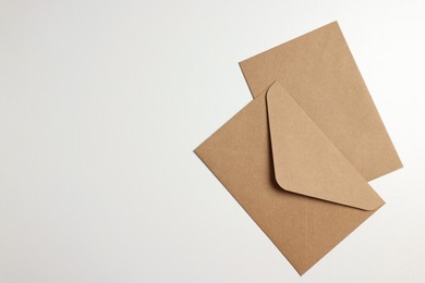 Photo of Envelopes made of parchment paper on white background, flat lay. Space for text