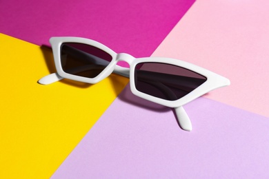 Photo of Stylish sunglasses on color background. Summer time