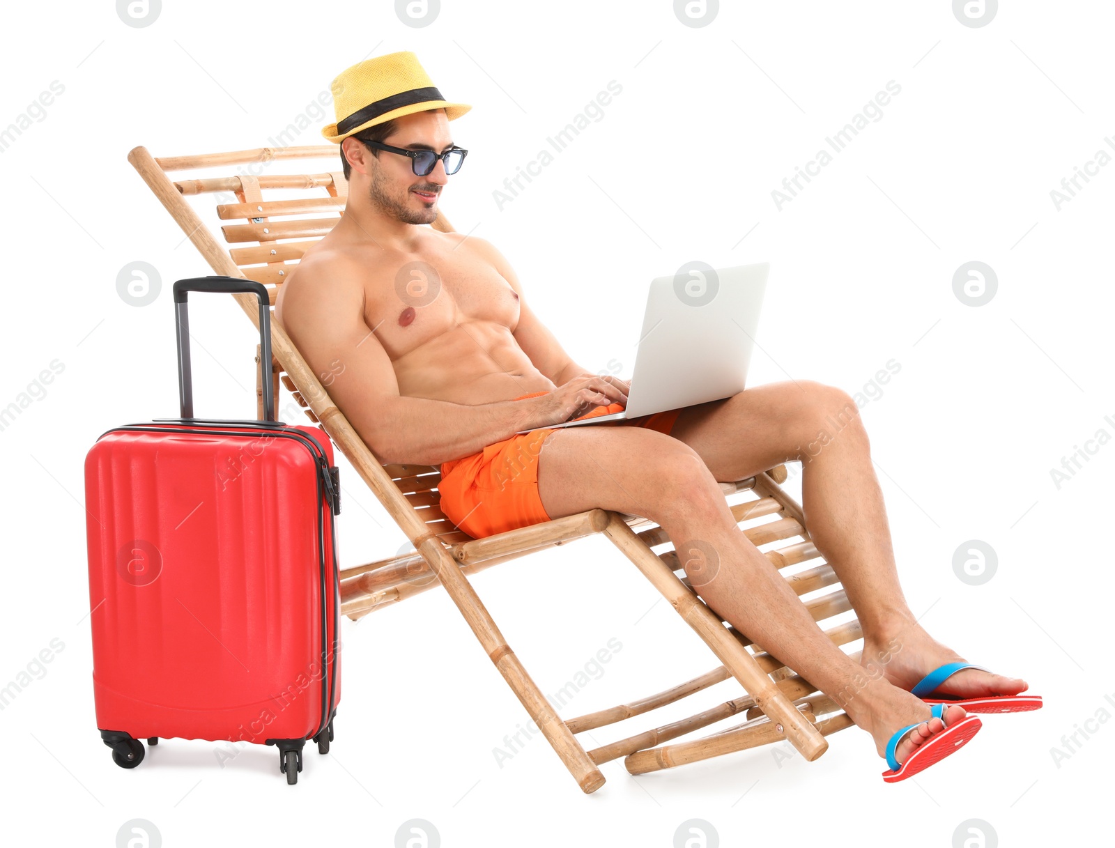 Photo of Young man with laptop and suitcase on sun lounger against white background. Beach accessories