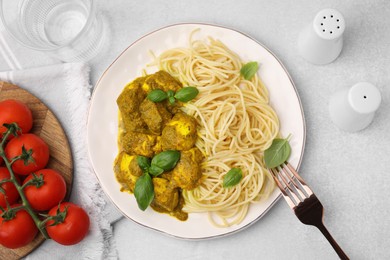 Delicious pasta and chicken with curry sauce served on white table, flat lay