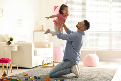 Photo of Father playing with his child at home