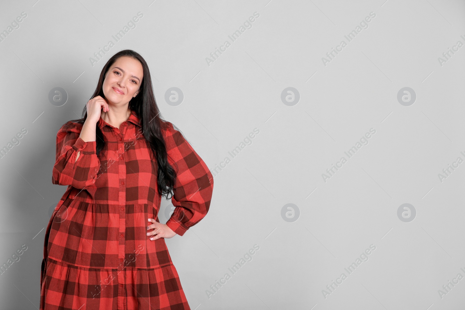 Photo of Beautiful overweight woman with charming smile on light grey background. Space for text