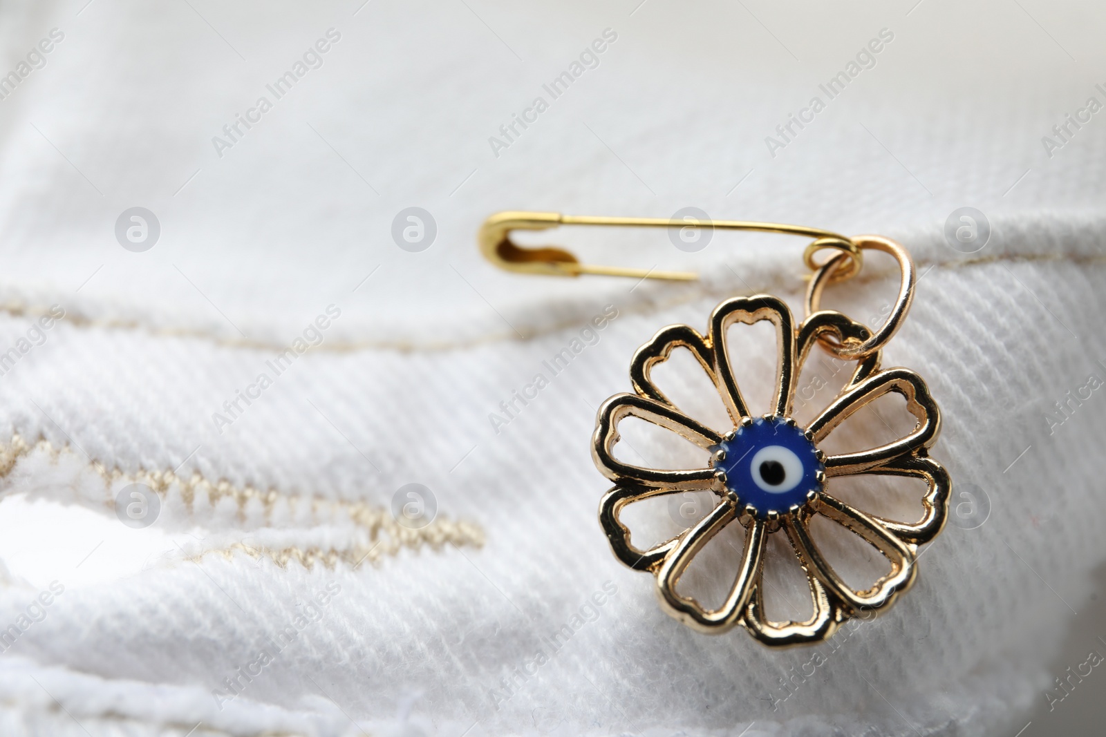 Photo of Evil eye safety pin on clothing, closeup