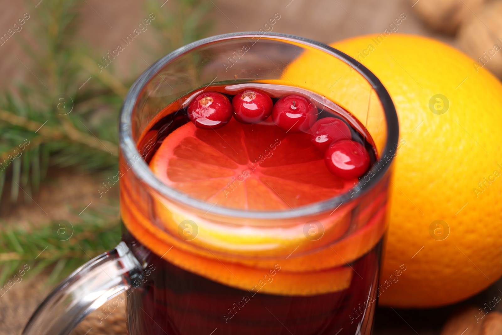 Photo of Aromatic mulled wine in glass cup on table, closeup