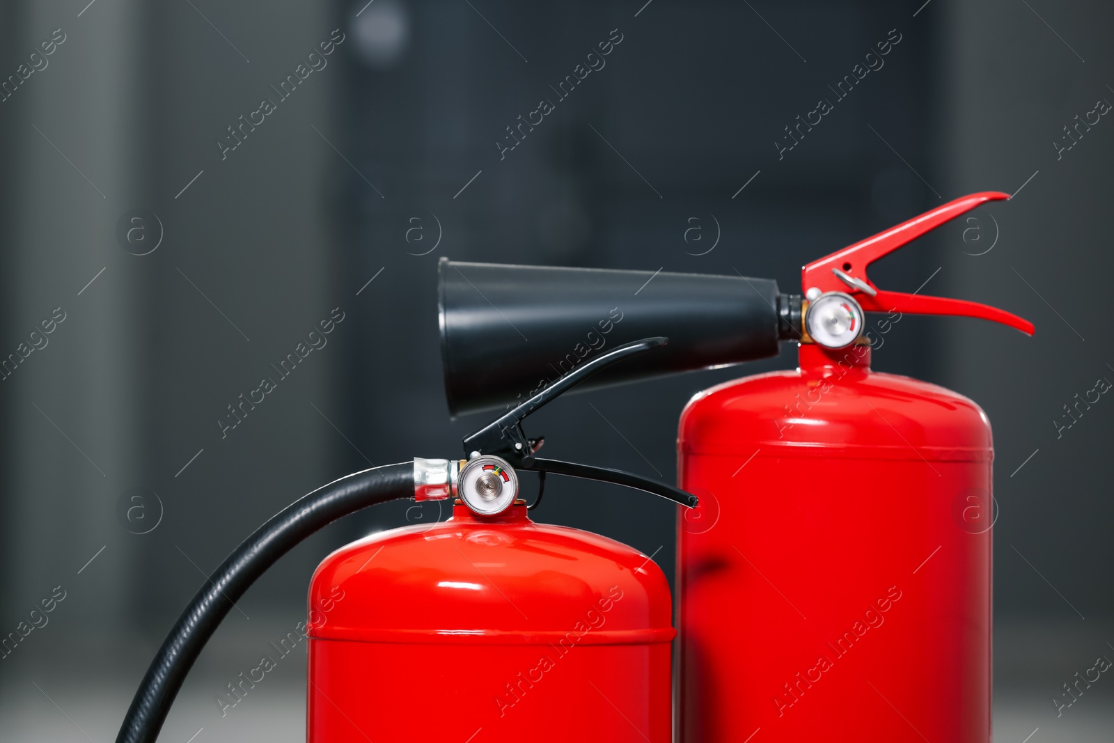 Photo of Two red fire extinguishers in hall, closeup view