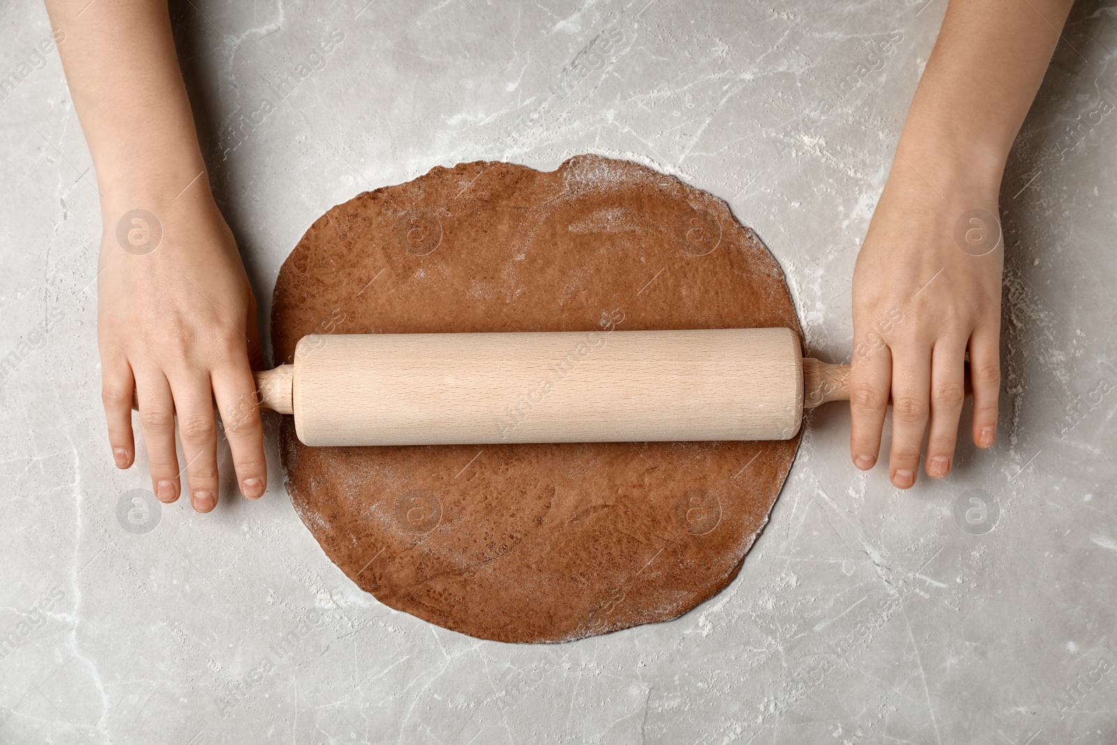 Photo of Woman rolling fresh dough on table, top view