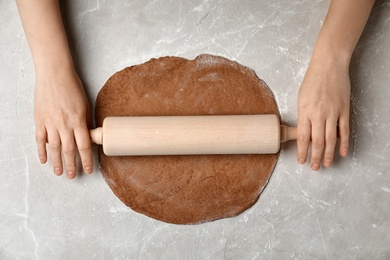 Photo of Woman rolling fresh dough on table, top view