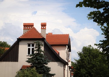 Photo of Beautiful house with brown roof against cloudy sky