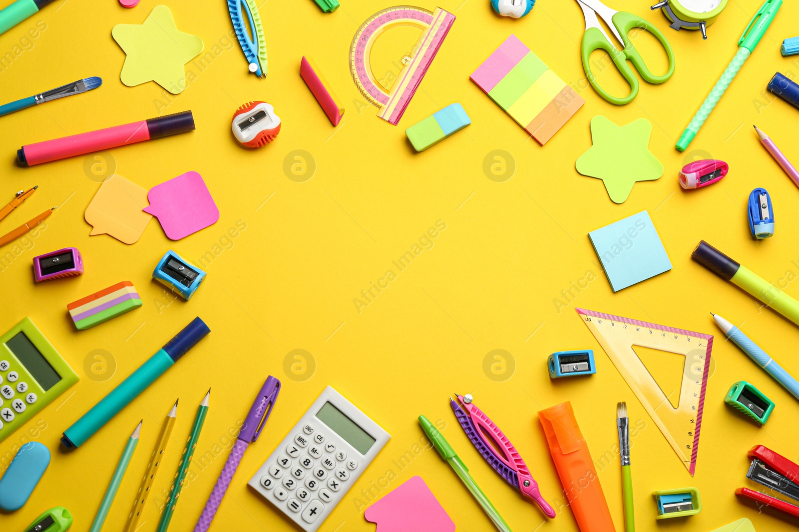 Photo of Frame of different school stationery on yellow background, flat lay with space for text. Back to school