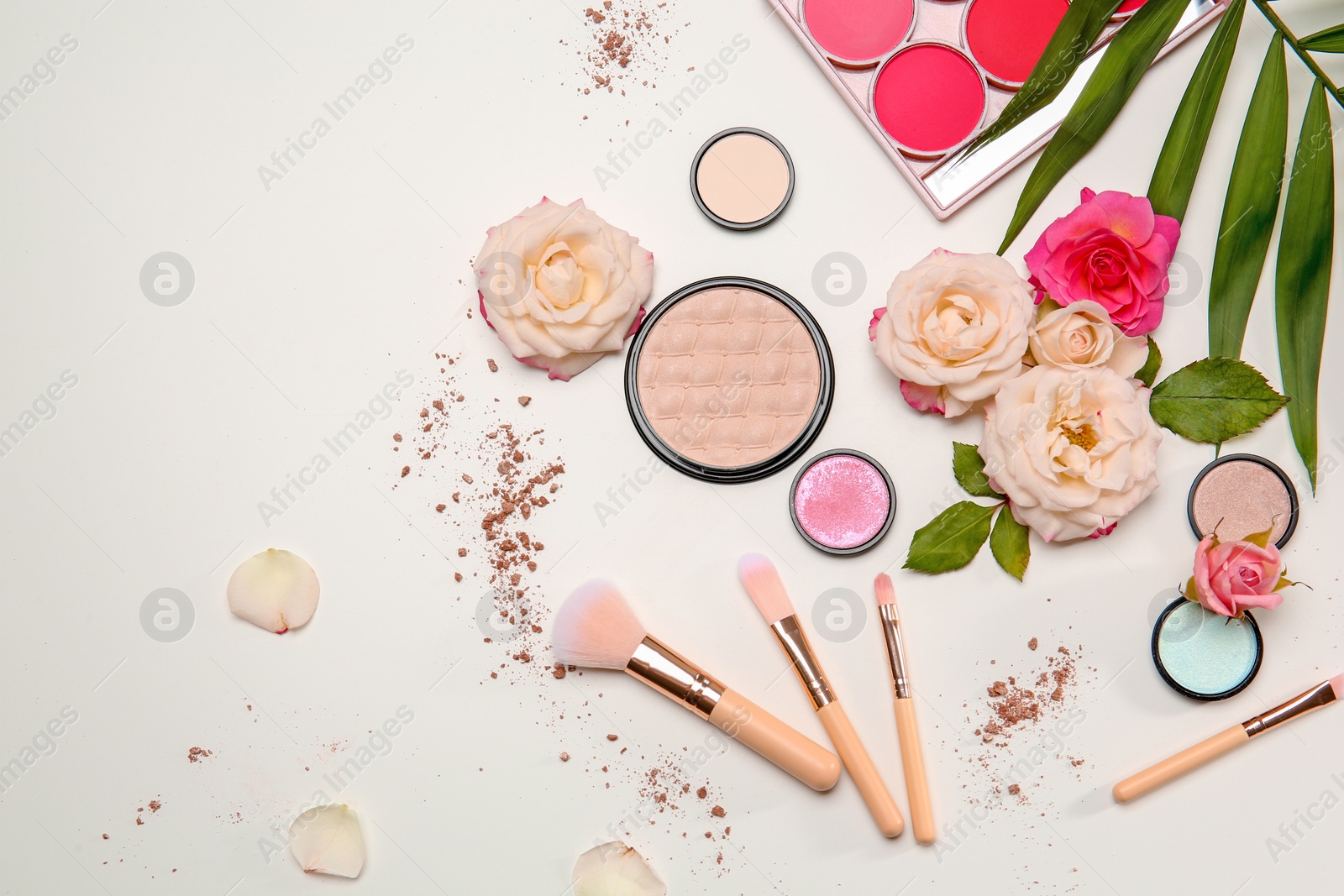 Photo of Flat lay composition with makeup brushes, cosmetic products and flowers on white background